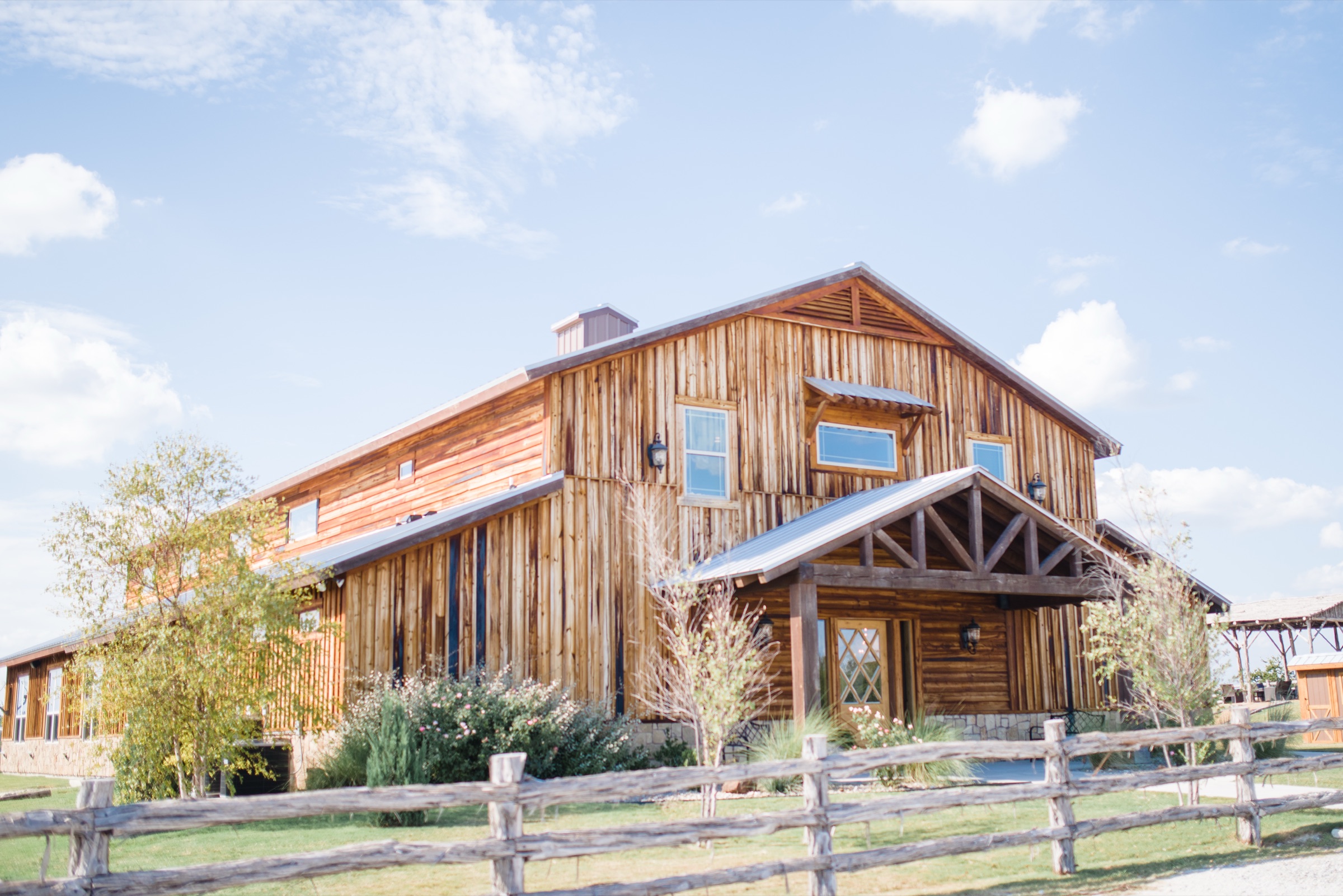 The cedar reception barn at Diamond H3 Ranch glowing at sunset over the Parker County hills