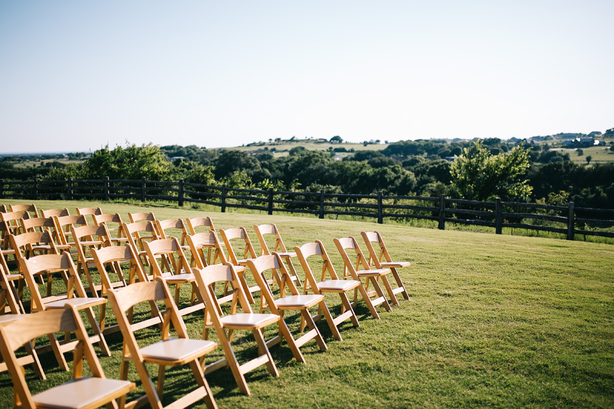 Outdoor ceremony site with wooden arbor overlooking the rolling Parker County hills
